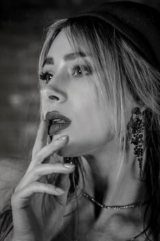 Captivating black and white portrait of an adult woman with elegant earrings, showcasing beauty and grace.