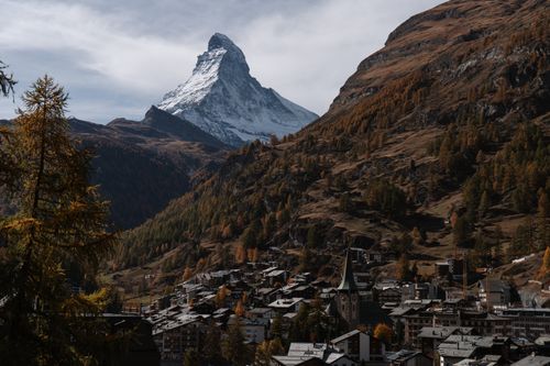 Stunning view of the Matterhorn towering over Zermatt, Switzerland, surrounded by autumn foliage.