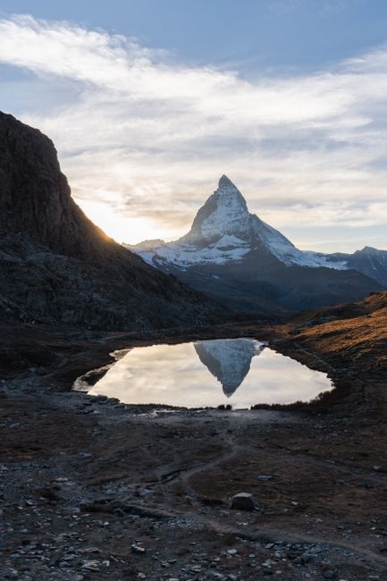 Stunning sunrise view of the Matterhorn reflected in a tranquil mountain lake in Zermatt, Switzerland.