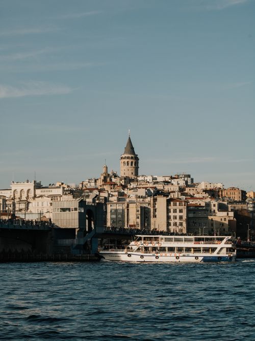 Free Beautiful view of Istanbul's historic Galata Tower and waterfront with a boat on the Bosphorus. Stock Photo