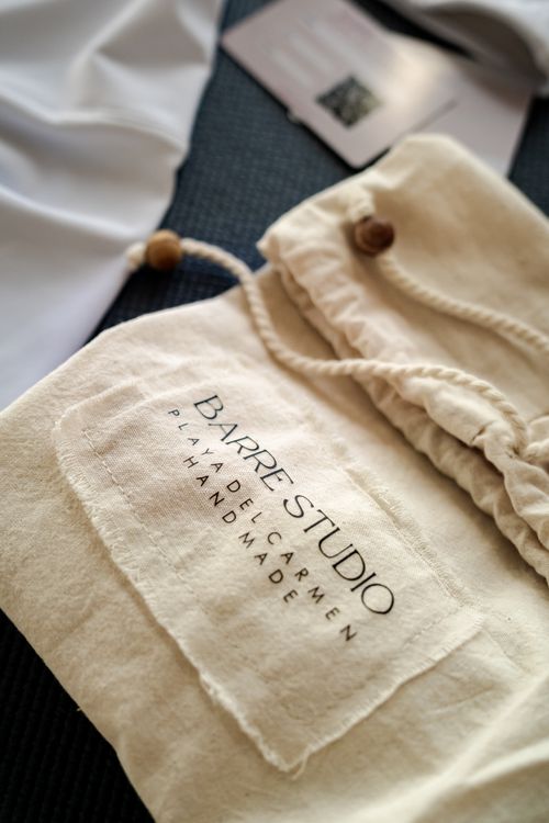 Free Close-up of a handmade fabric bag with text 'BARRE STUDIO Playa Del Carmen' on a surface. Stock Photo