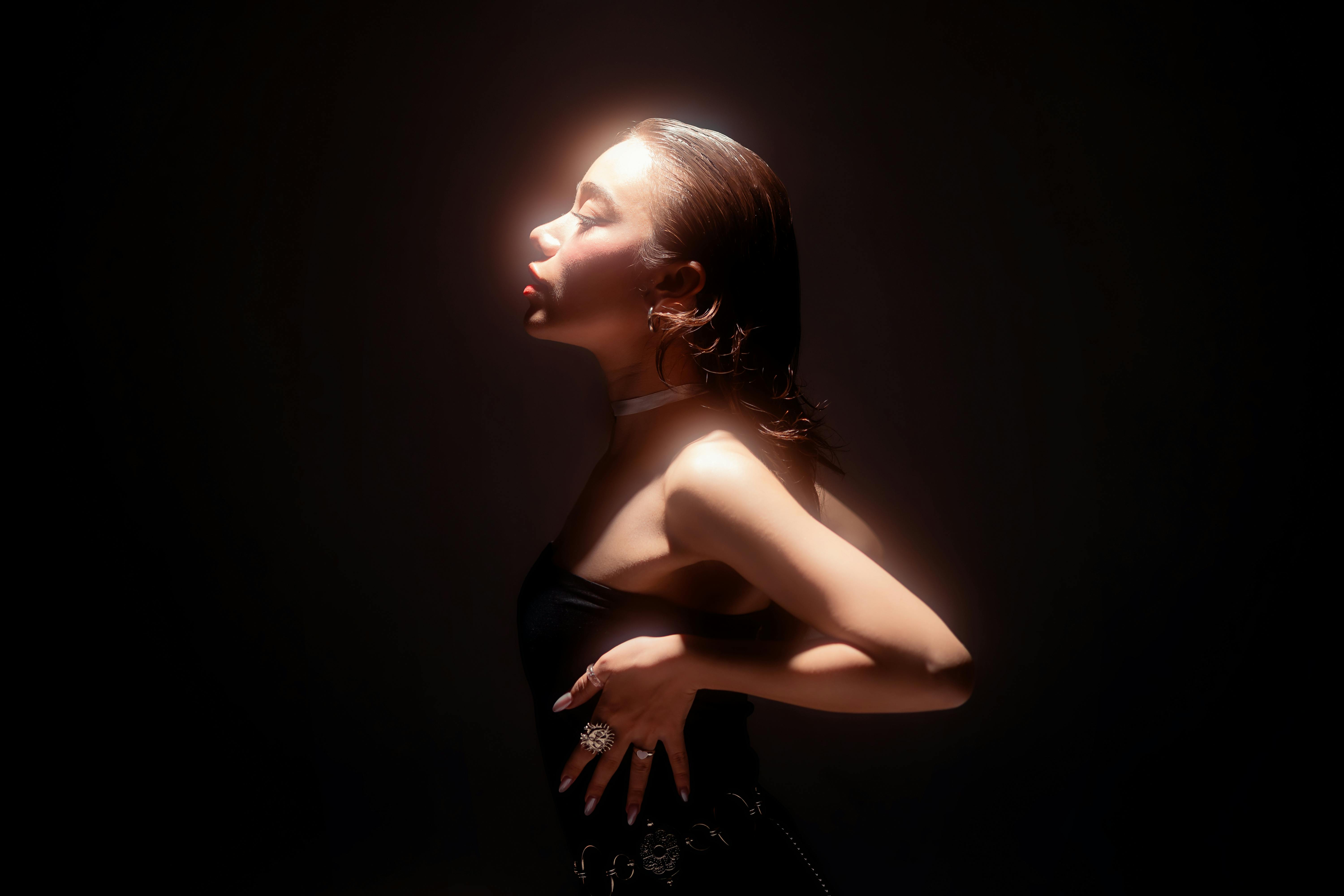 Side profile of a woman in artistic lighting, highlighting elegance and mood.