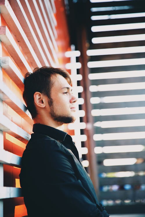 Man Wearing Black Dress Shirt Leaning On Wall