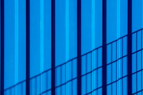 Free Blue wall with bold shadows creating a striking geometric pattern. Stock Photo
