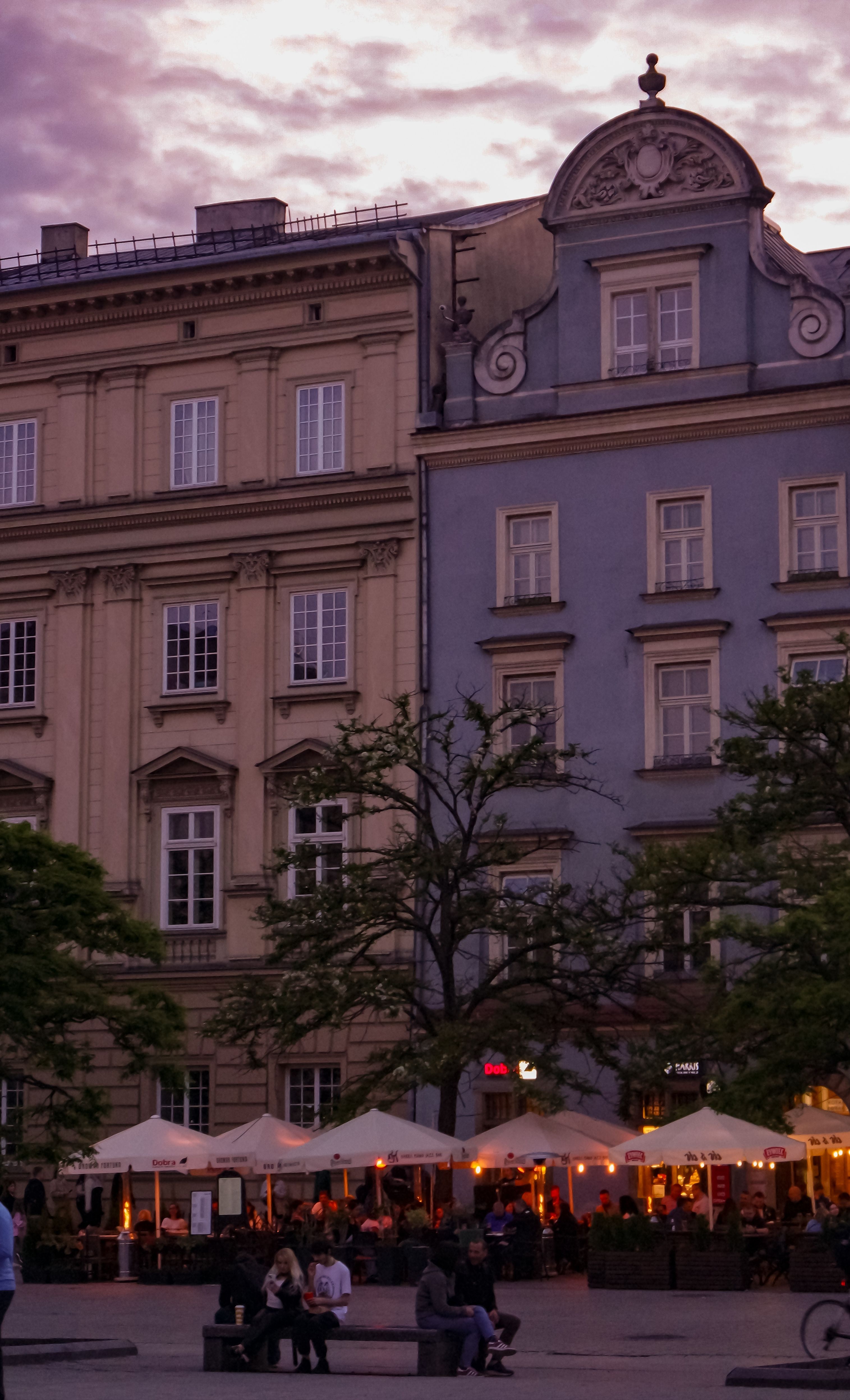 Historic European architecture with vibrant cafes at twilight.