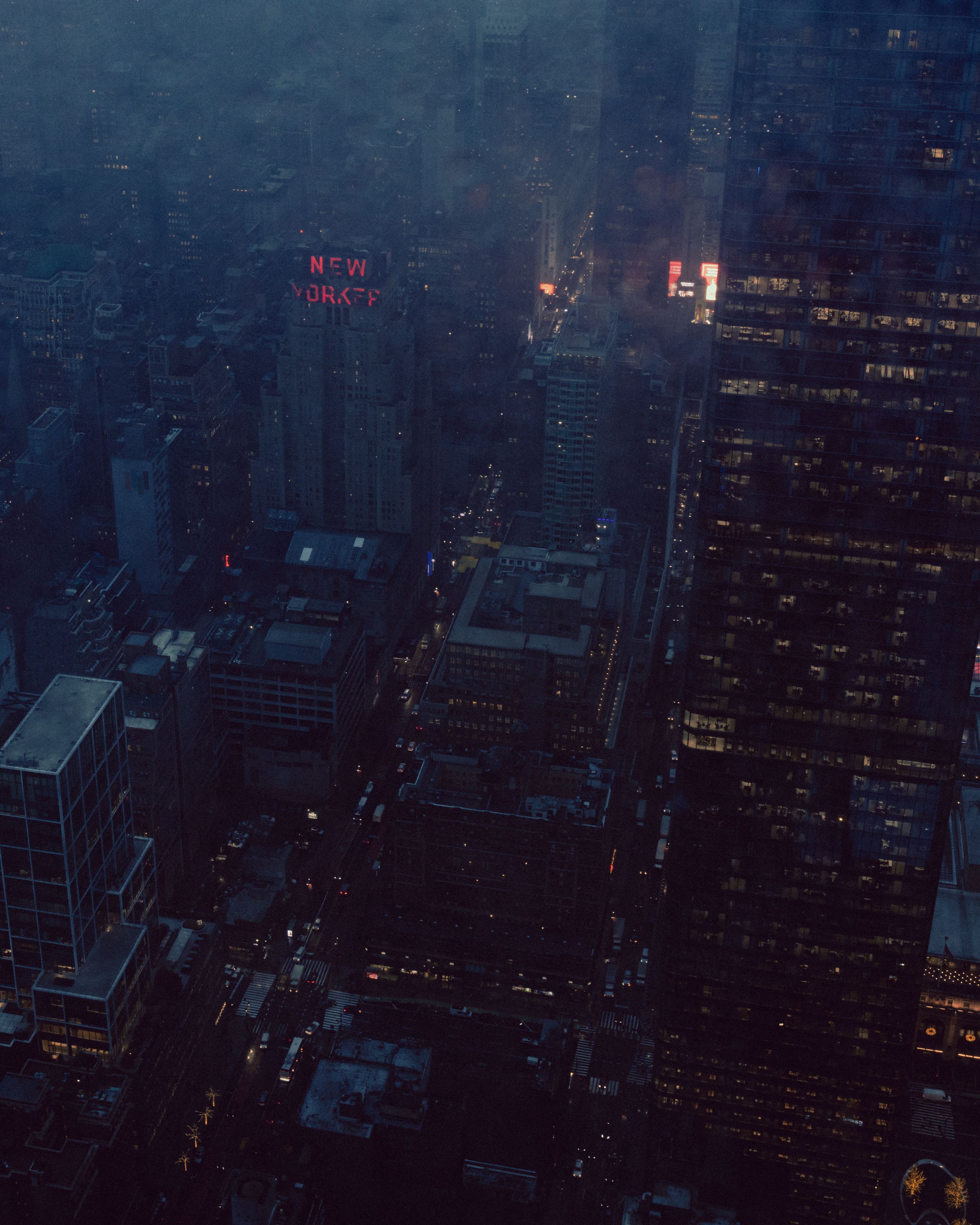 A dramatic aerial view of New York City at night with illuminated skyscrapers and glowing city lights.