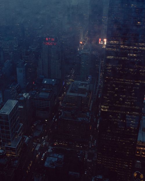 Free A dramatic aerial view of New York City at night with illuminated skyscrapers and glowing city lights. Stock Photo