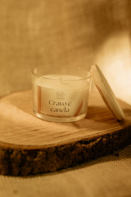 Free Elegant candle with clove and cinnamon aroma on a wooden slab in warm light. Stock Photo