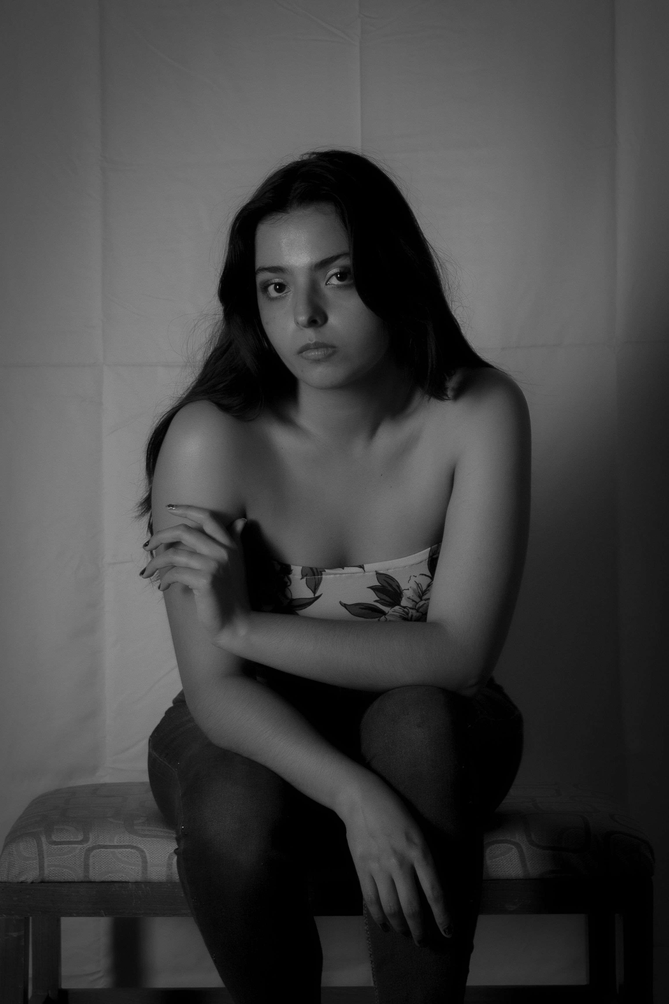 Fotomural Retrato en blanco y negro de una mujer sentada, exudando elegancia y contemplación.