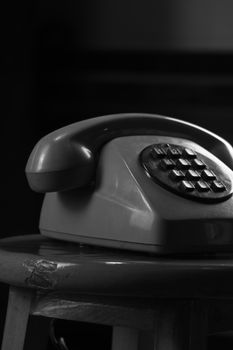 Close-up of a vintage rotary telephone in monochrome, symbolizing retro communication.