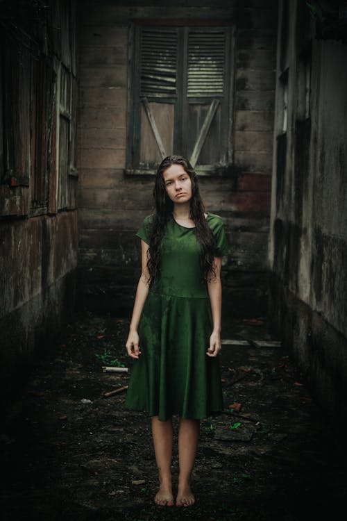 Free Woman in Green Dress Standing Outdoors Stock Photo