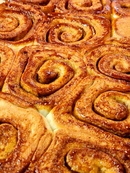 Free Freshly baked cinnamon rolls with warm, sweet aroma perfect for breakfast or dessert. Stock Photo