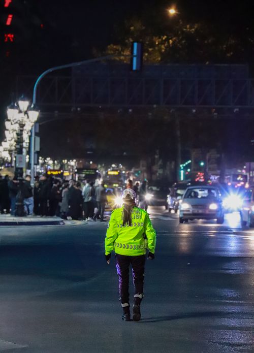 Free A traffic officer in reflective gear manages city nightlife traffic. Stock Photo