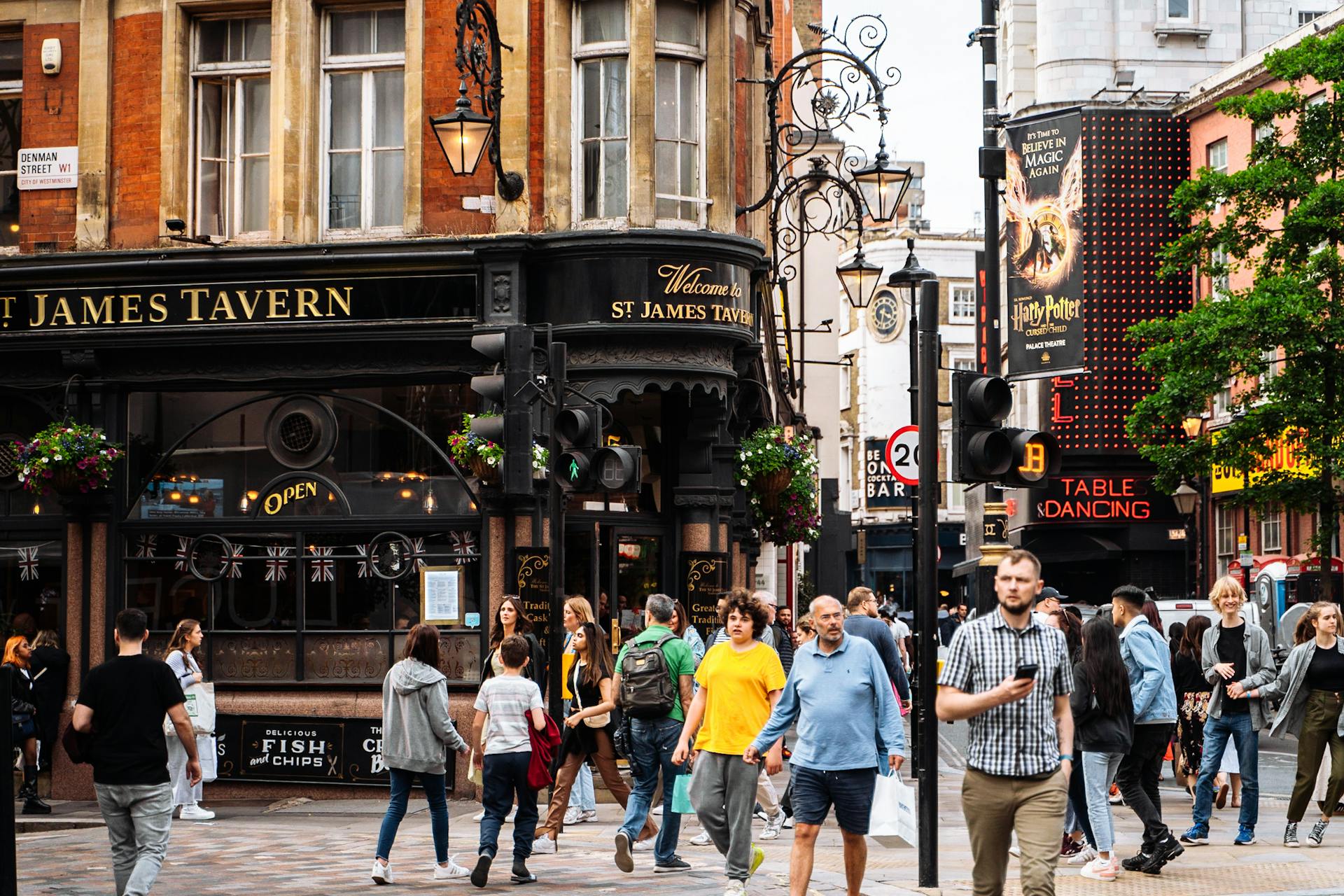 Busy street scene with pedestrians outside St. James Tavern in London, capturing the lively urban atmosphere.