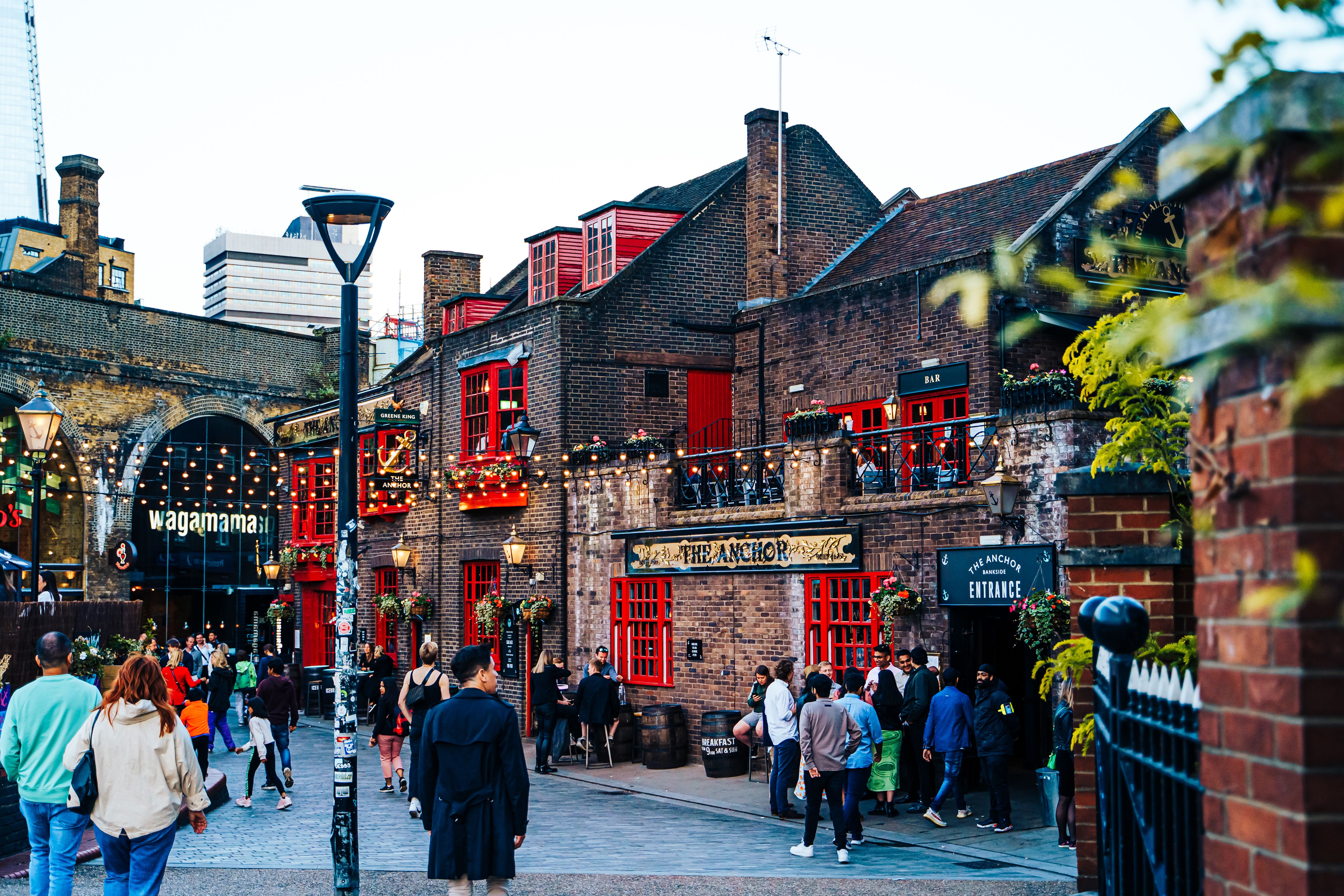 Vibrant evening at The Anchor Pub in London with people enjoying the lively atmosphere.