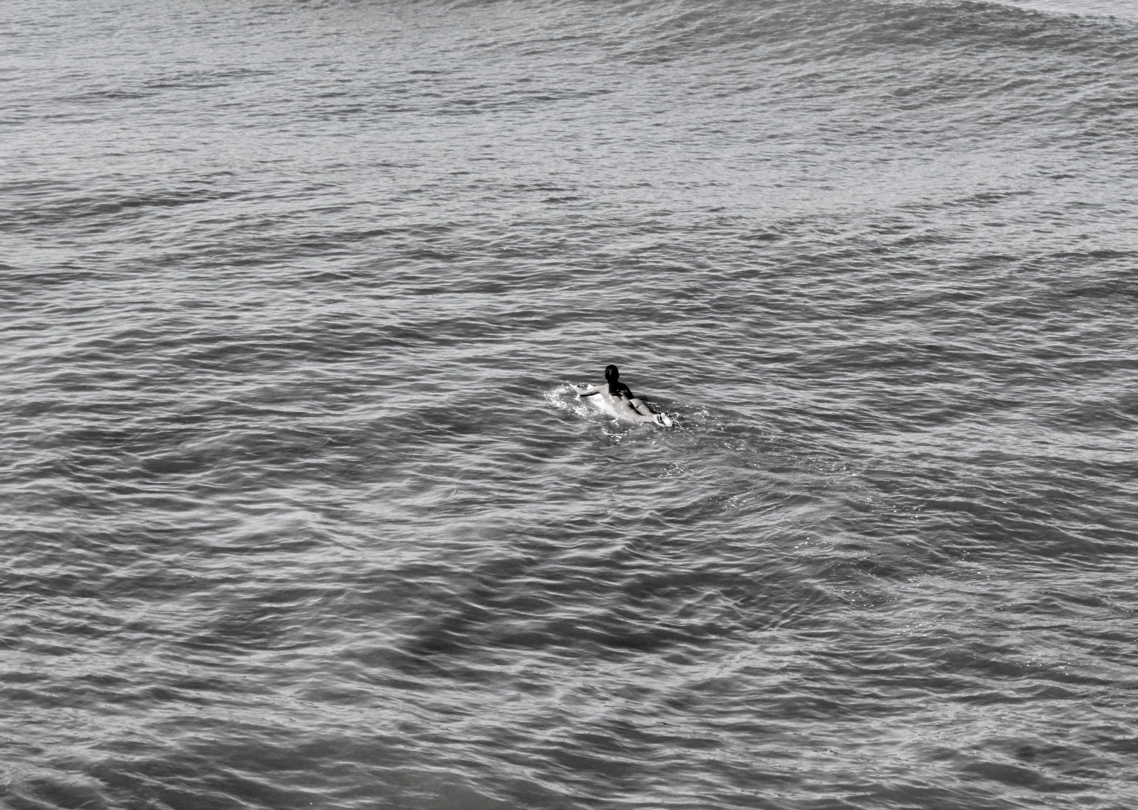 A lone surfer paddles through the Atlantic Ocean waves off the coast of Brazil.