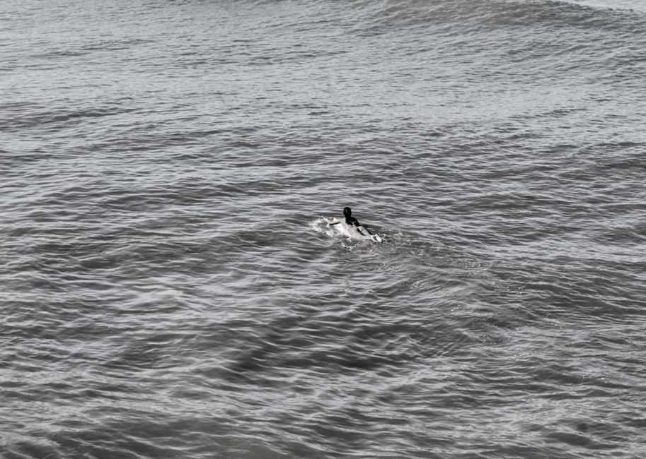 A lone surfer paddles through the Atlantic Ocean waves off the coast of Brazil.