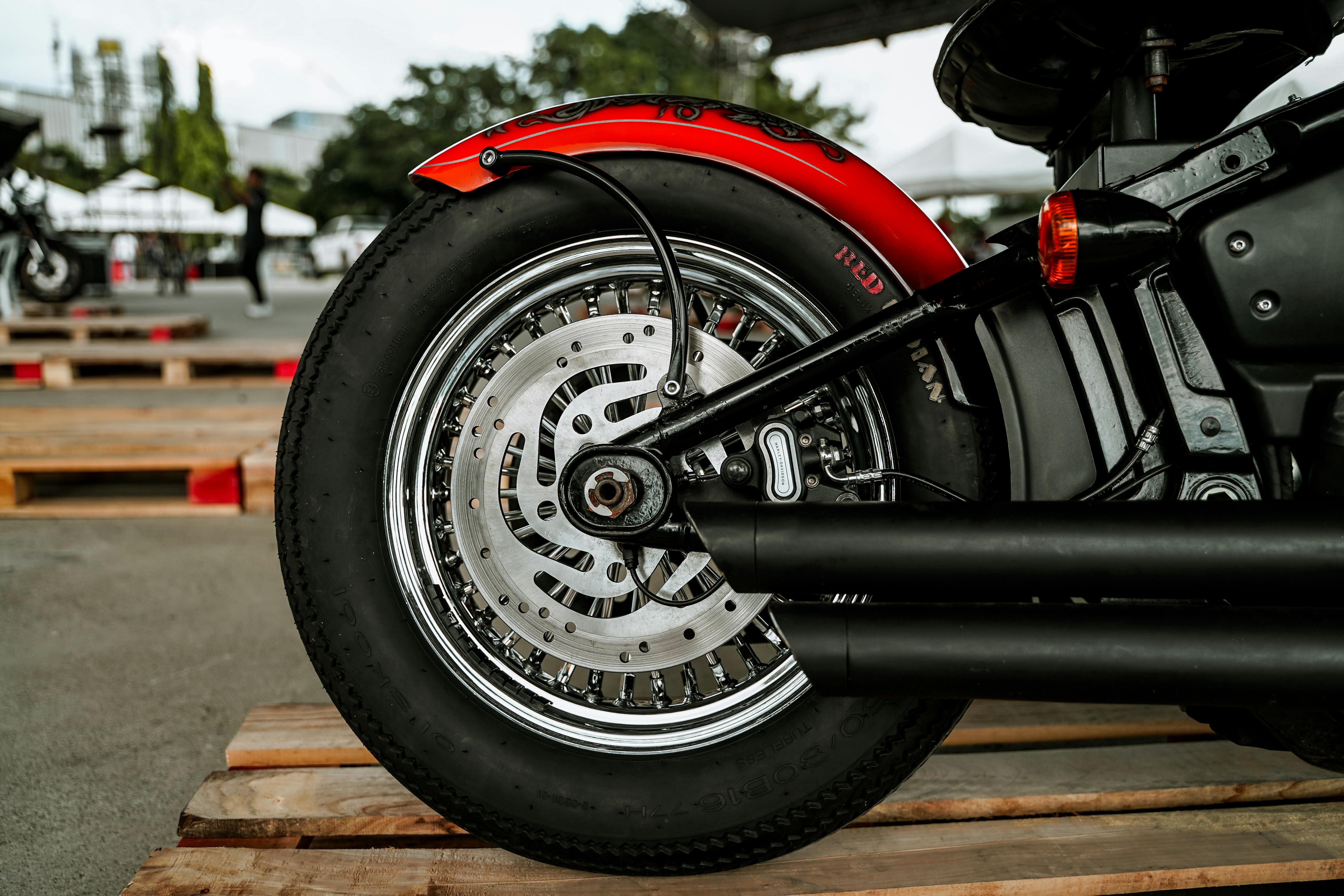 Detailed view of a motorcycle wheel, focusing on chrome detailing and smooth tire.