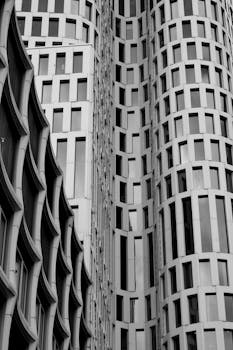 Black and white photo of modern architecture showcasing vertical lines and window patterns.