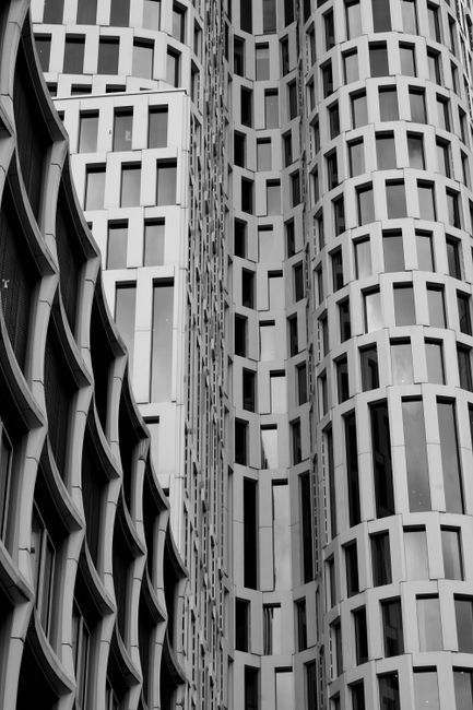 Black and white photo of modern architecture showcasing vertical lines and window patterns.