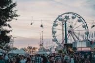 日落时分，人群在游乐园里享受摩天轮等游乐设施