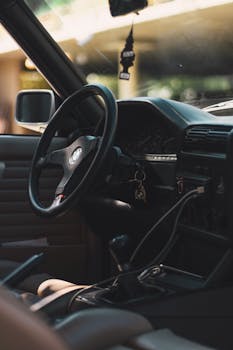 老式宝马汽车内饰特写，重点展示方向盘和仪表板