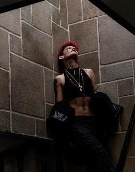 Stylish woman with tattoos and red hair posing in cool urban setting, Mexico City.