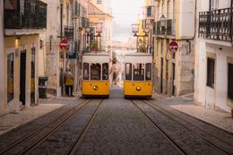 Yellow trams on a cobbled Lisbon street — photo by Naimish Verma on Pexels