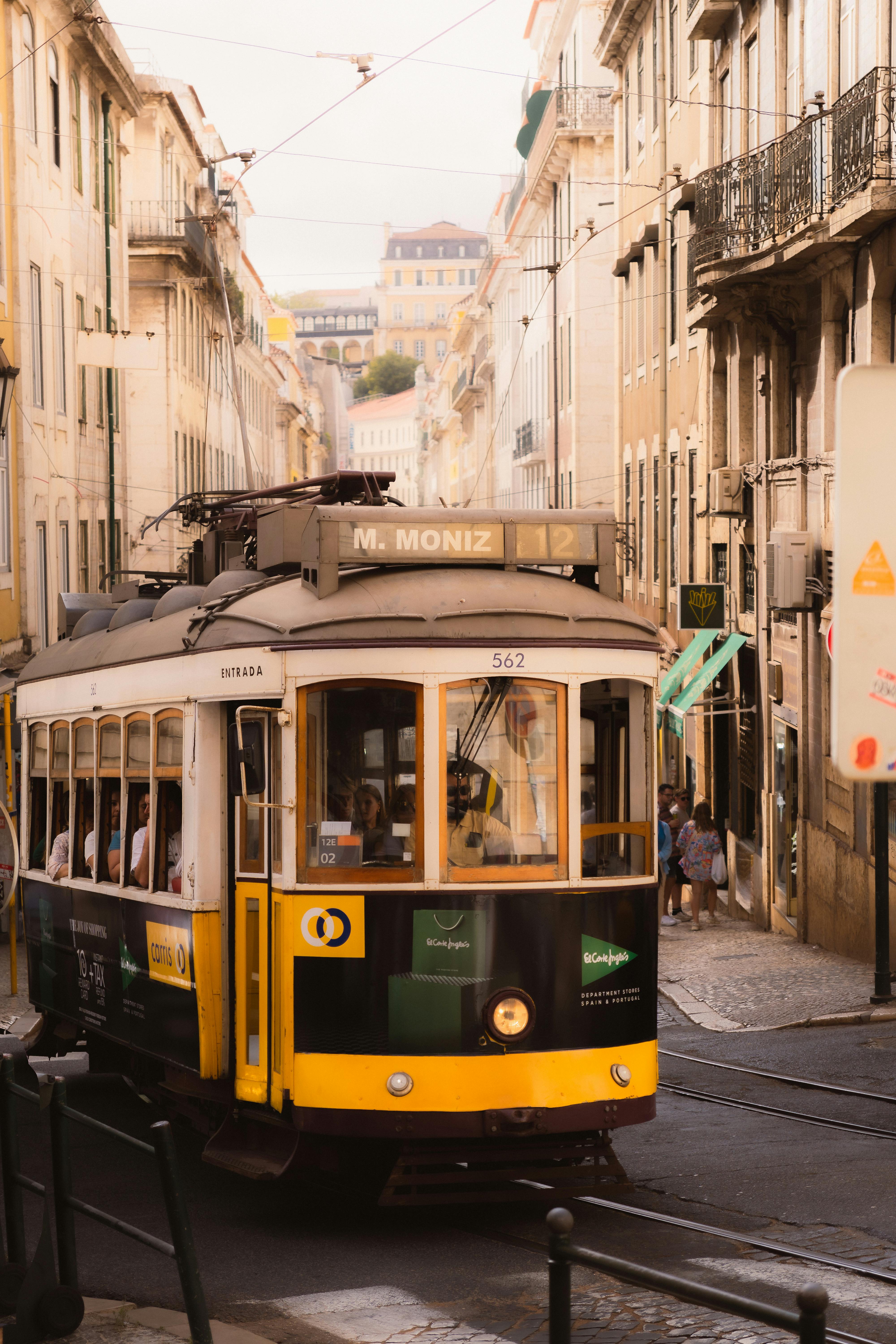 Charming yellow tram passing through Lisbon's historic Alfama district
