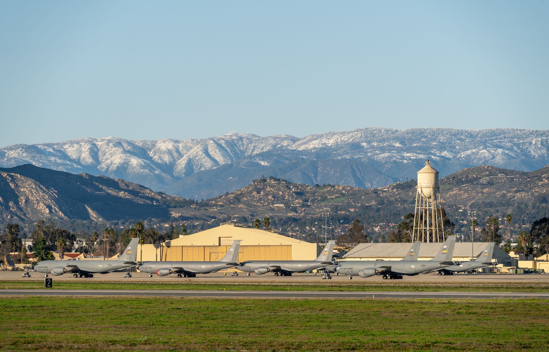 U.S. Air Force planes stationed at March Air Reserve Base with snow-capped mountains in the background.