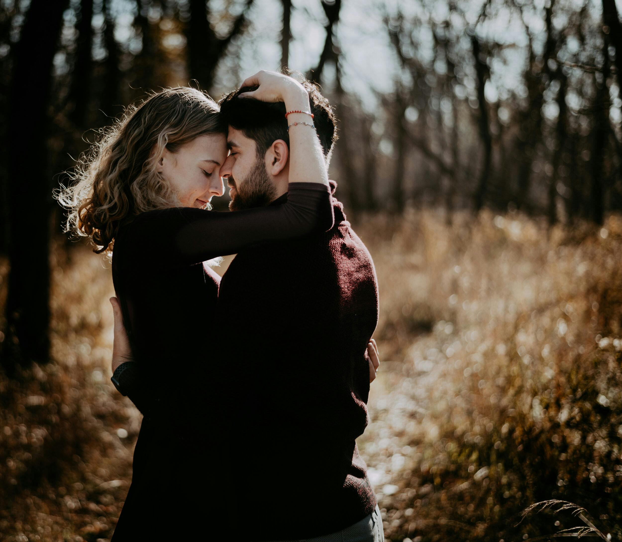 A couple embraces in a warm, romantic woodland setting near Seattle.