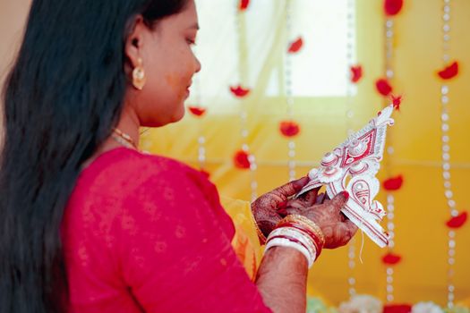 A Bengali bride holding a traditional mukut during a wedding ceremony in Kolkata, India.