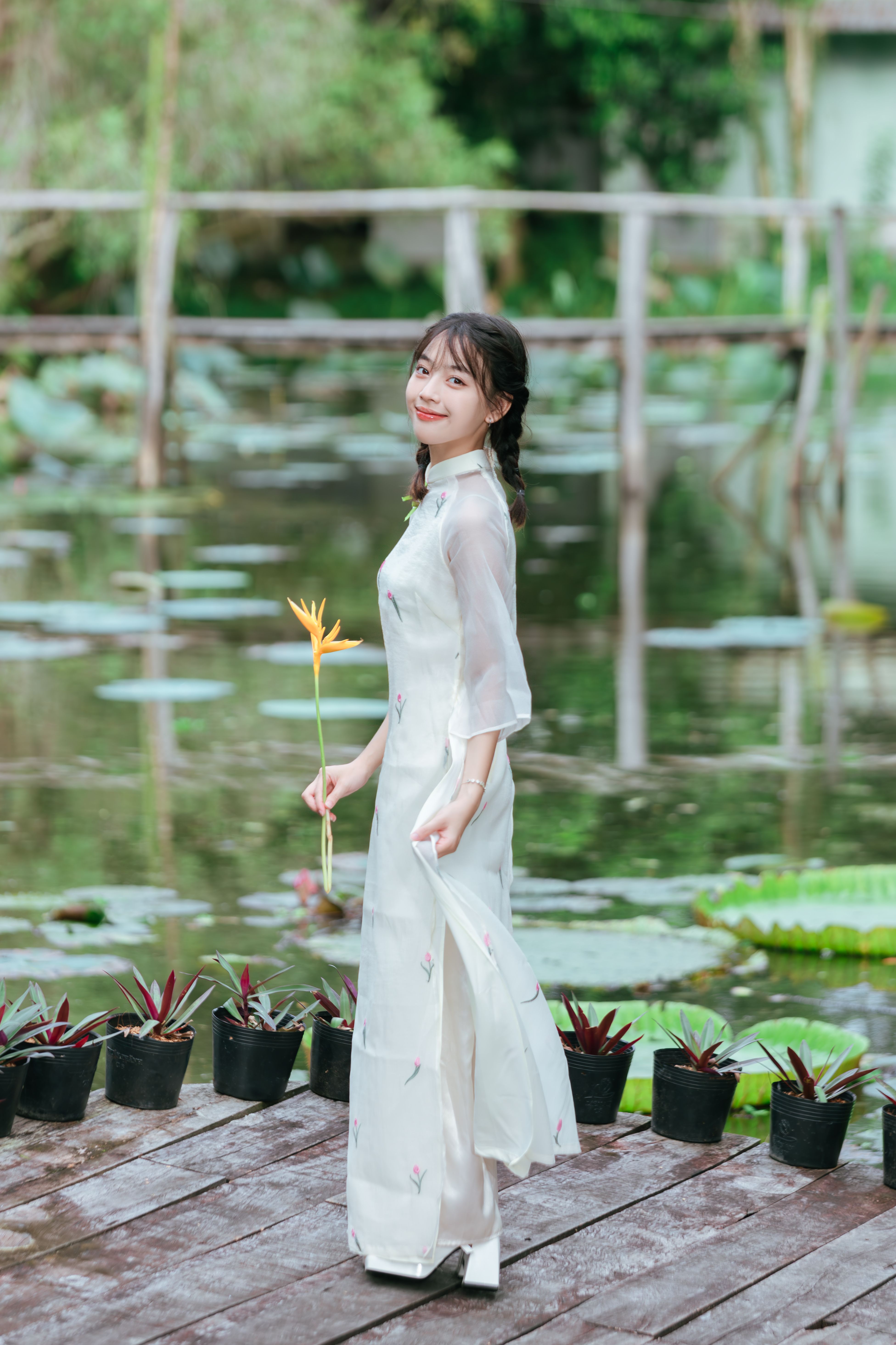 Young Woman in Traditional Dress Holding Flower · Free Stock Photo