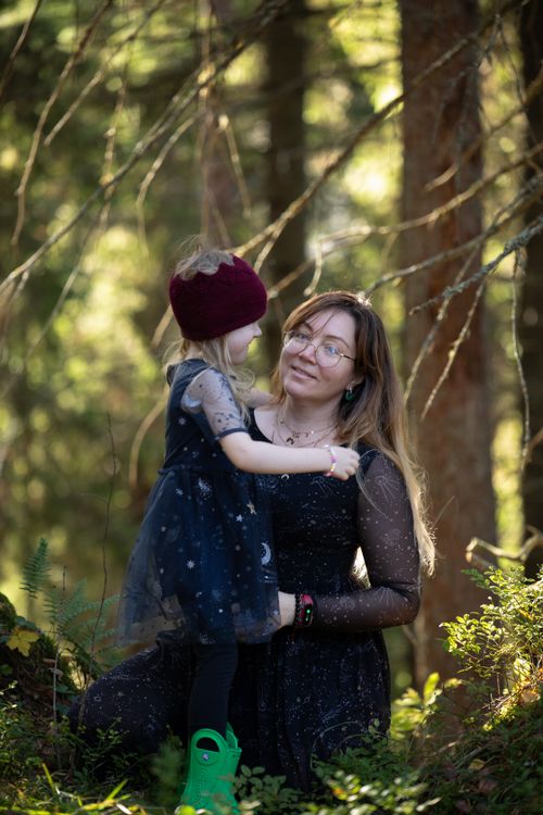 Free A mother and her daughter sharing a tender moment in a lush green forest. Stock Photo