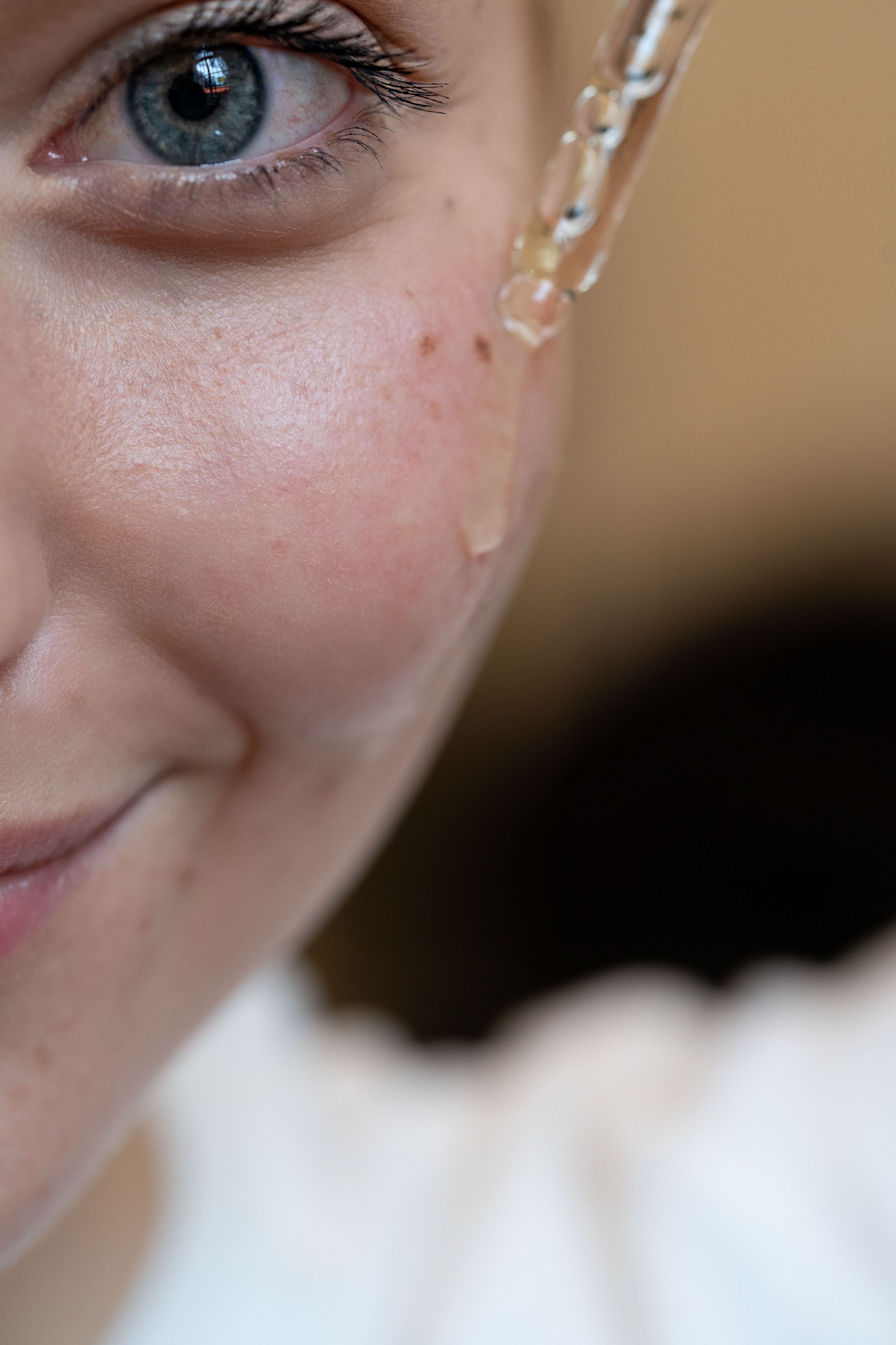 gratis Close-up van een persoon die huidverzorgingsserum aanbrengt met een druppelaar. Stockfoto
