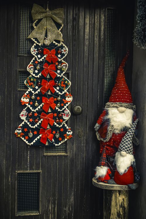 Free Creative Christmas decorations featuring Santa and a tree wreath on a wooden door. Stock Photo
