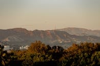 在风景优美的山丘背景下，戏剧性的日落景观捕捉了好莱坞的标志性标志