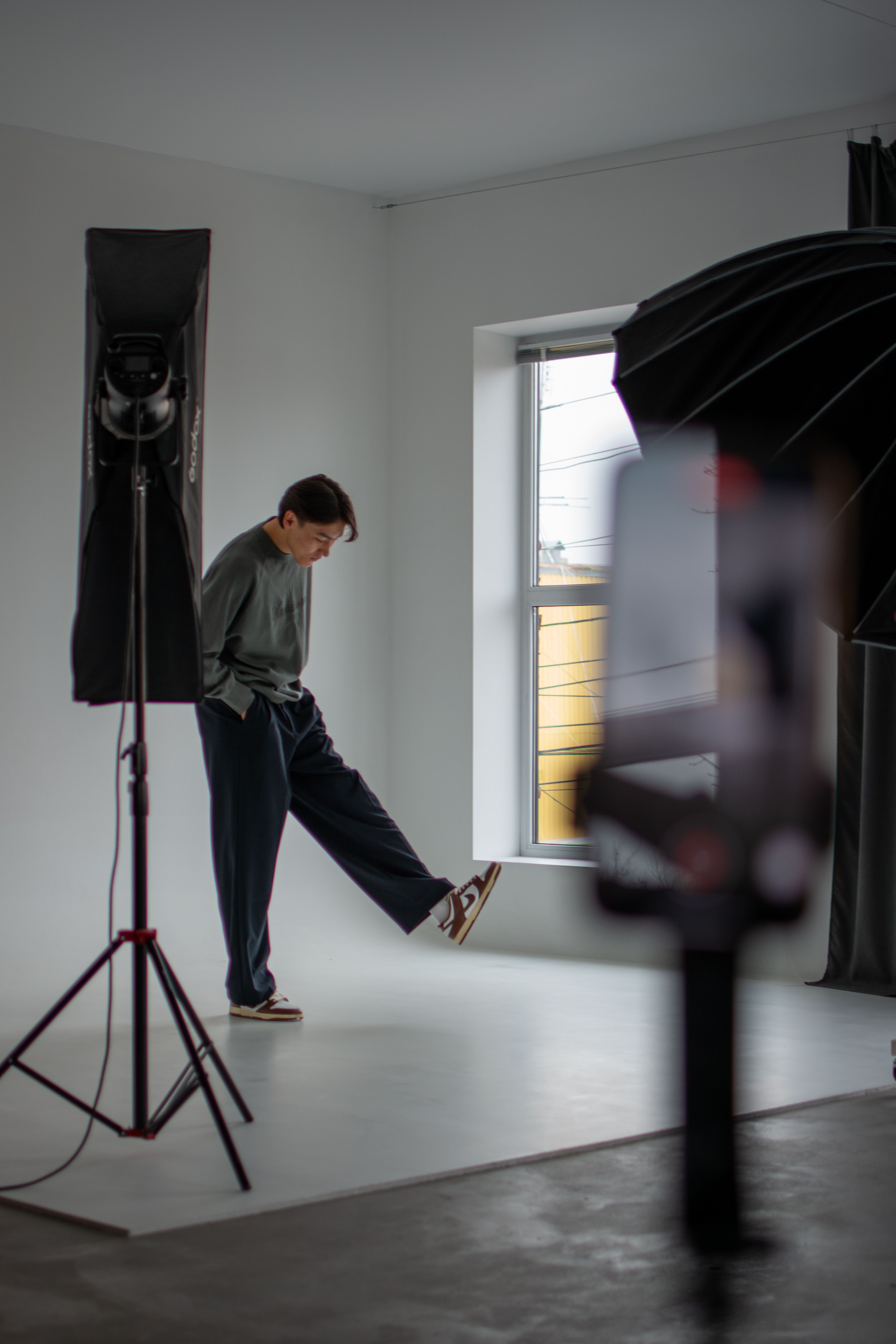 Man in a sleek photo studio setting with modern lighting.