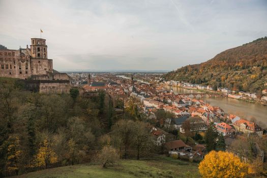 Heidelberg Castle and Old Town in autumn, viewed from above, showcasing historic architecture and colorful foliage.