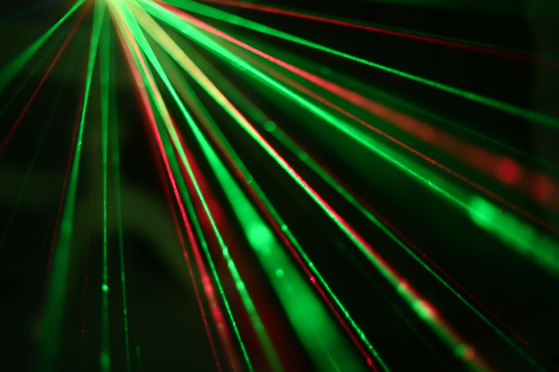 Vibrant display of red and green laser light beams creating dynamic patterns.