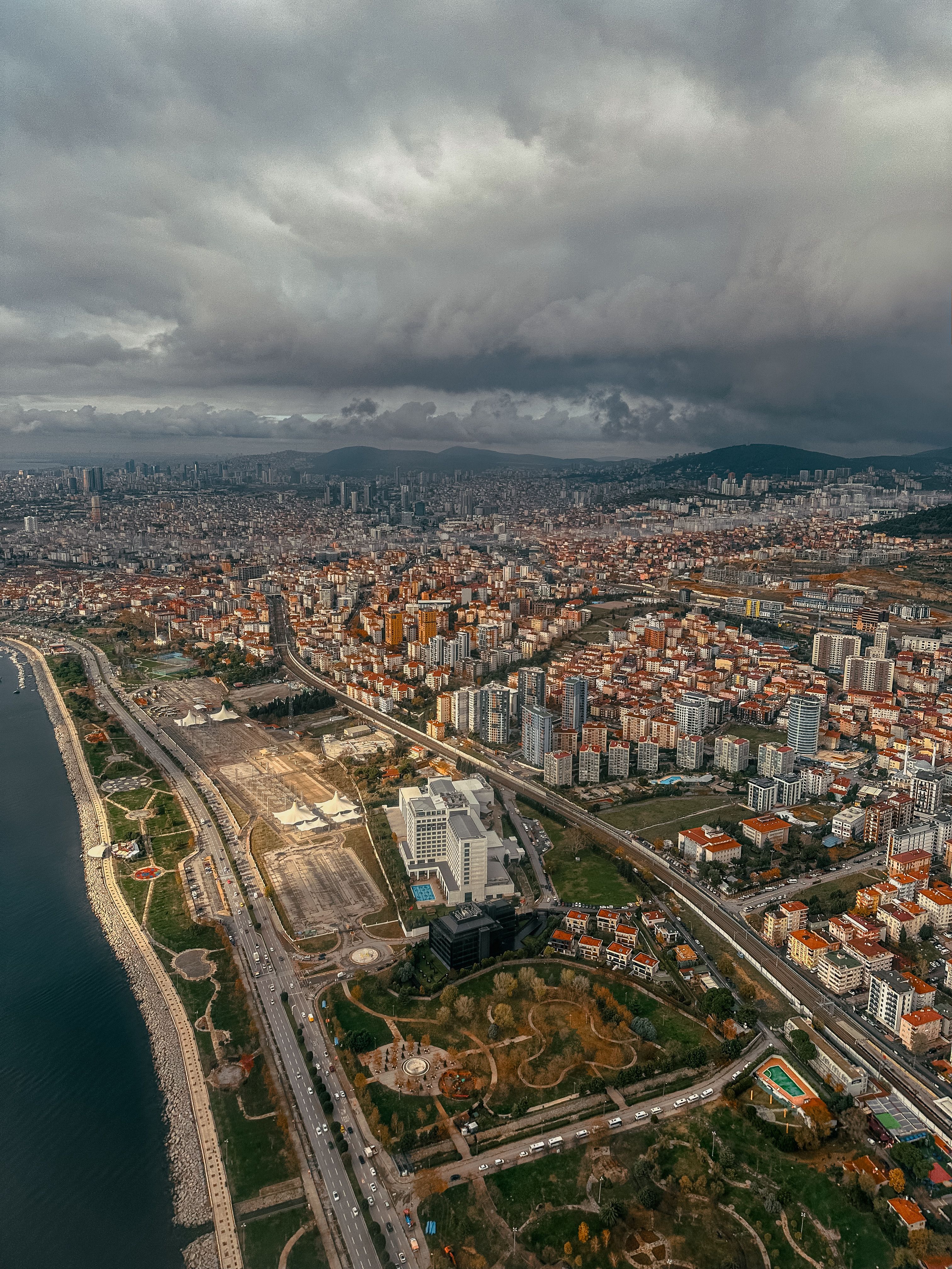 Aerial View of Urban Coastal Cityscape under Cloudy Sky · Free Stock Photo