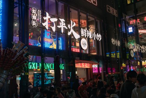 Free Dynamic street view of neon-lit restaurant in bustling nightlife area. Stock Photo