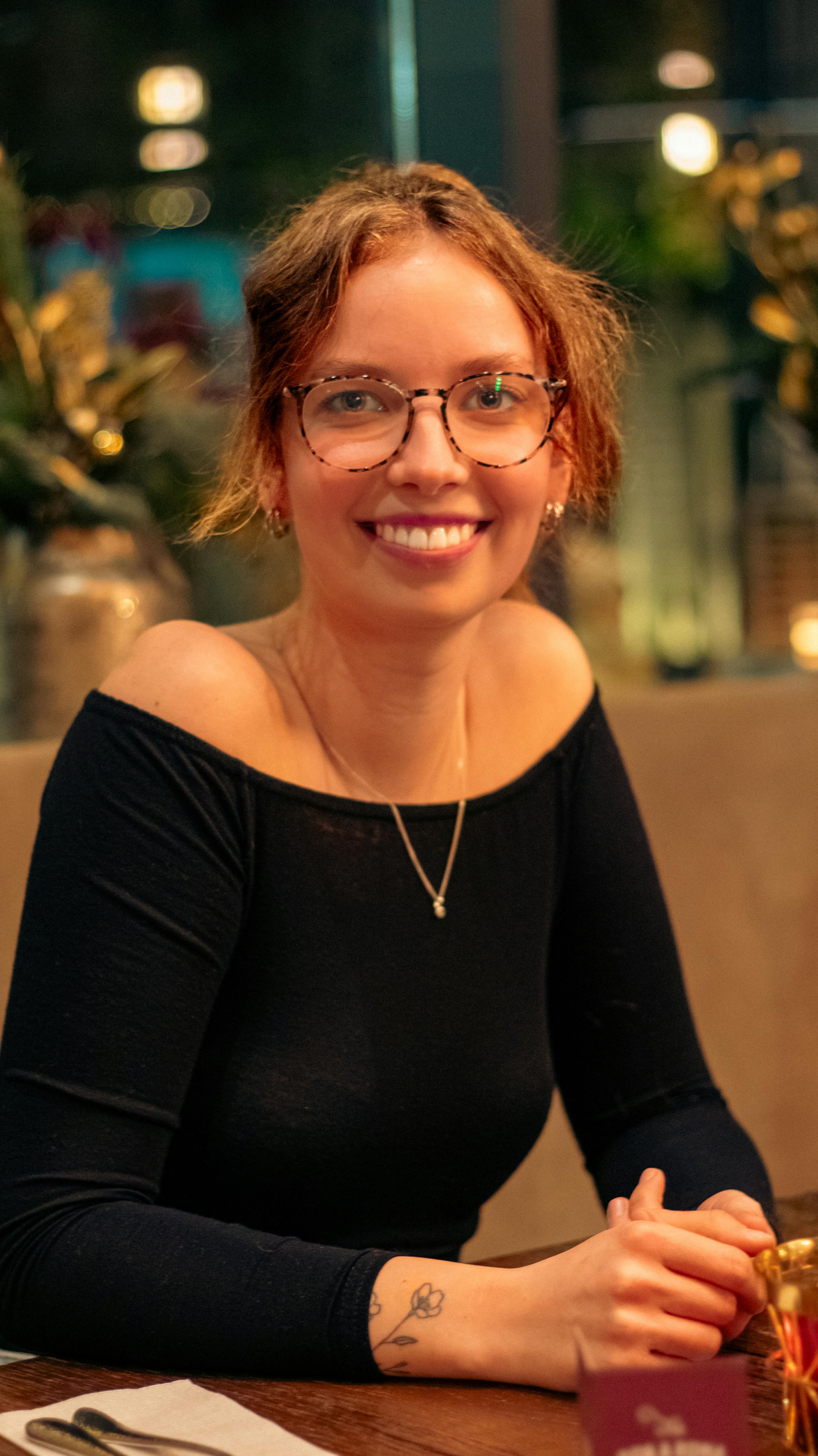 smiling woman sitting at a restaurant table