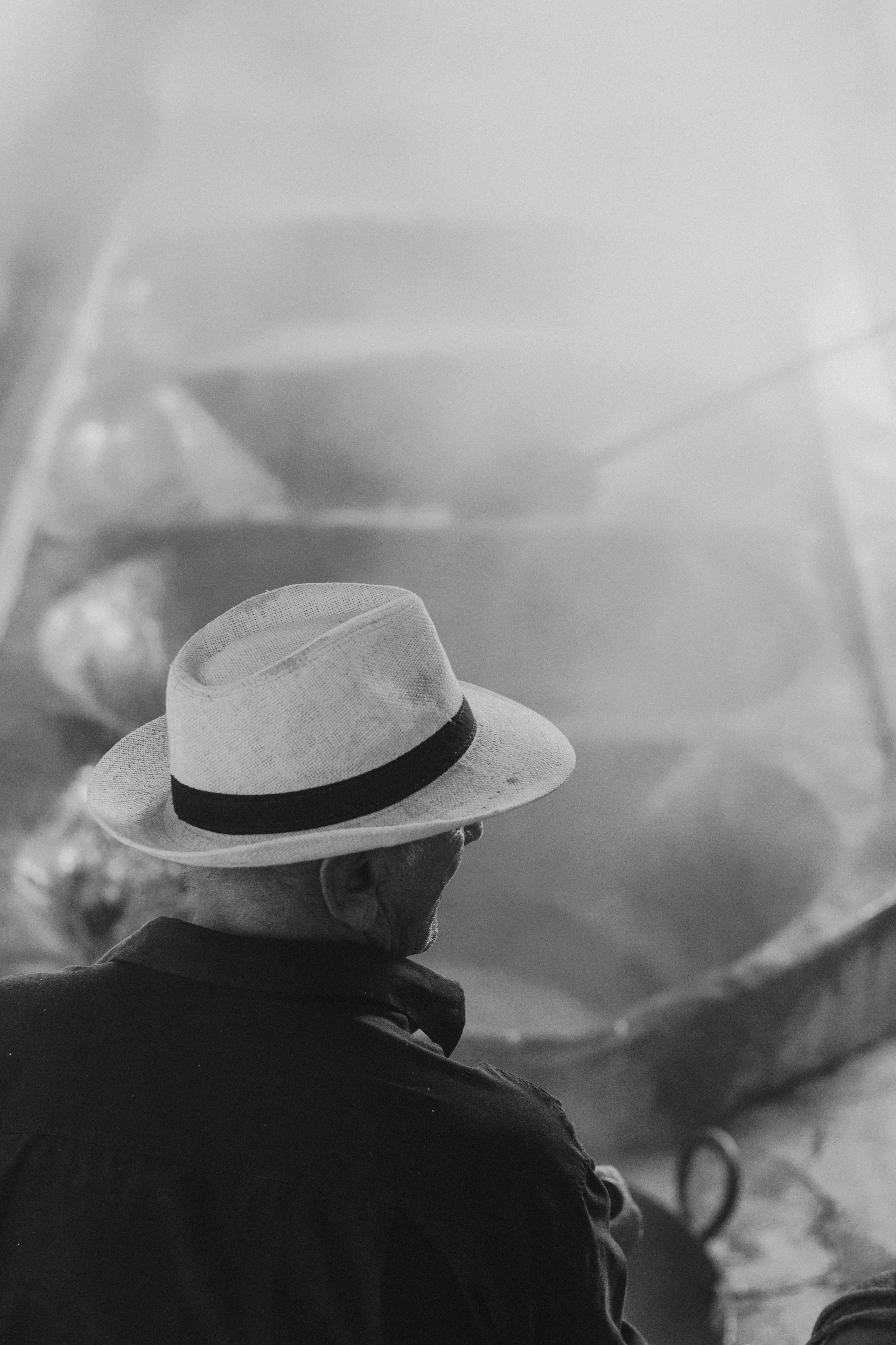 gratis Monochrome foto van een man met een hoed die grote dampende pannen bedient. Stockfoto