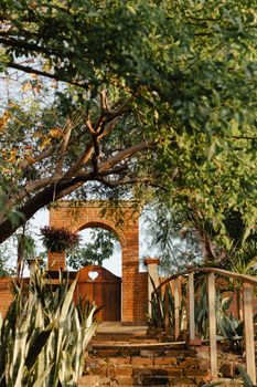 A picturesque garden entrance highlighted by a rustic brick arch and lush greenery.