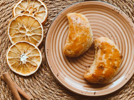 Delicious homemade pastries with dried oranges on a rustic table setting.