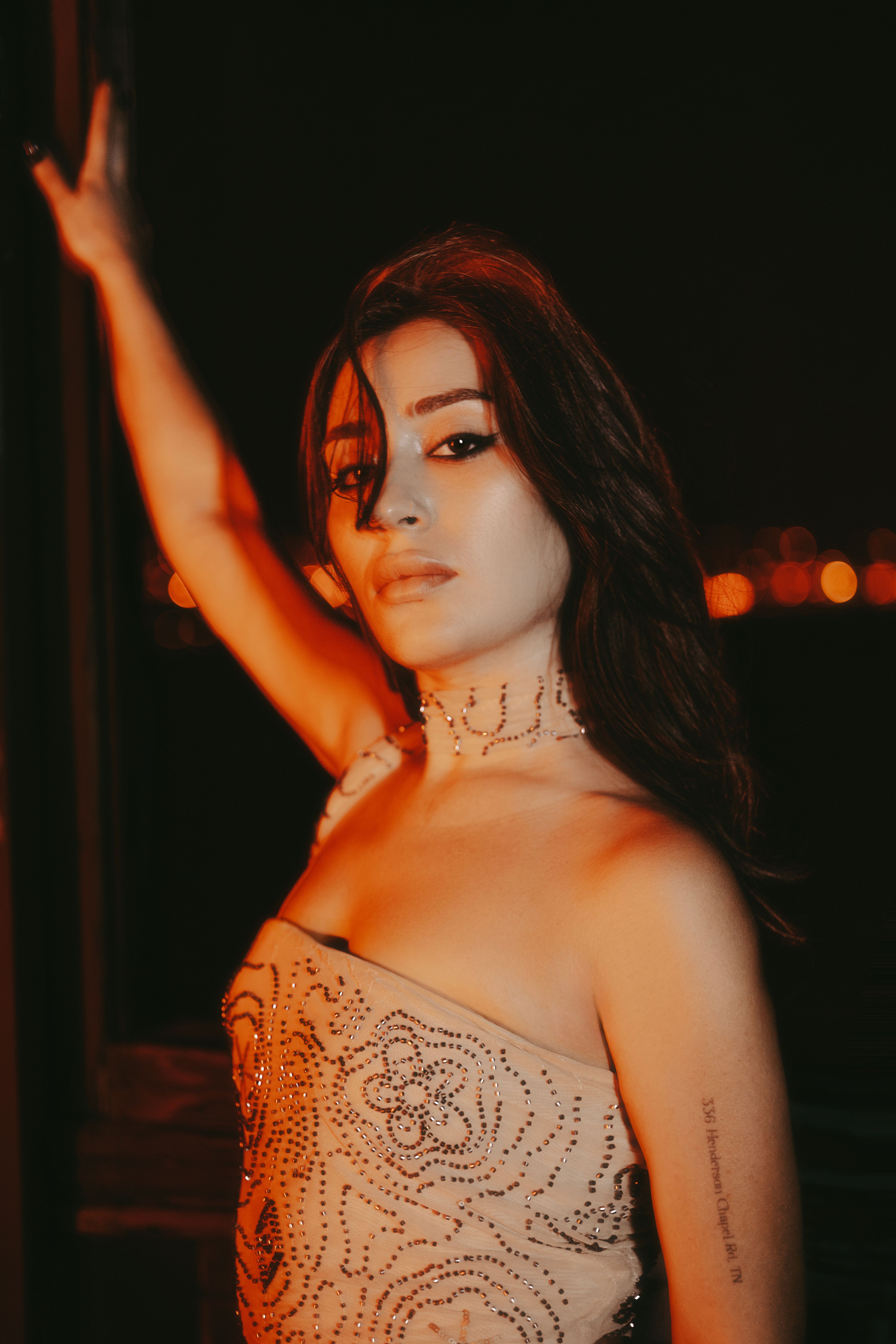 Elegant Woman Posing at Night with City Lights · Free Stock Photo