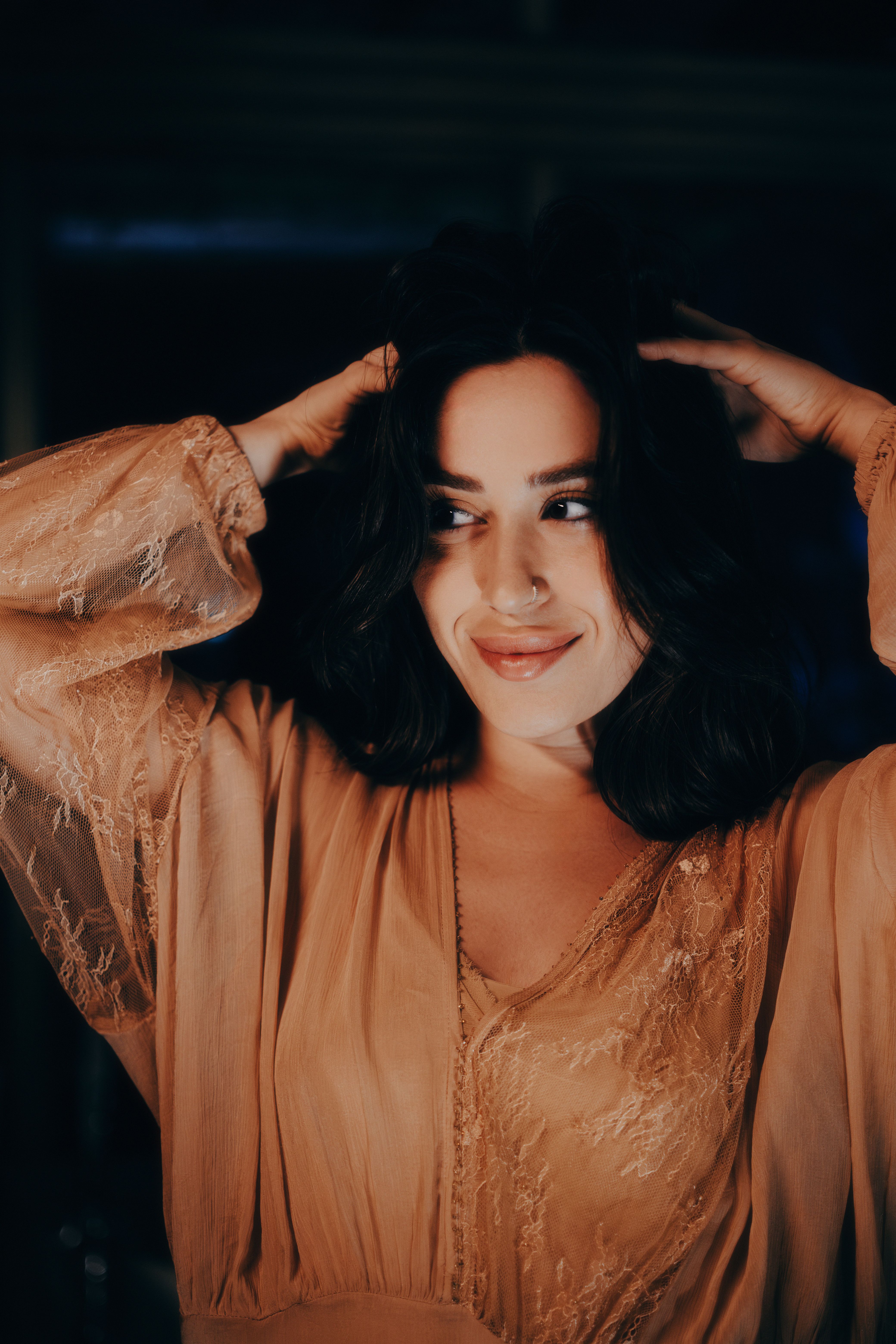 Portrait of an elegant woman in a warm glow, exuding confidence and charm.