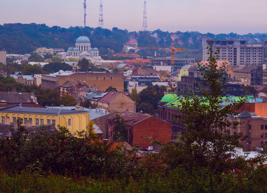 Aerial view of a historical European city with lush greenery and vibrant architecture.