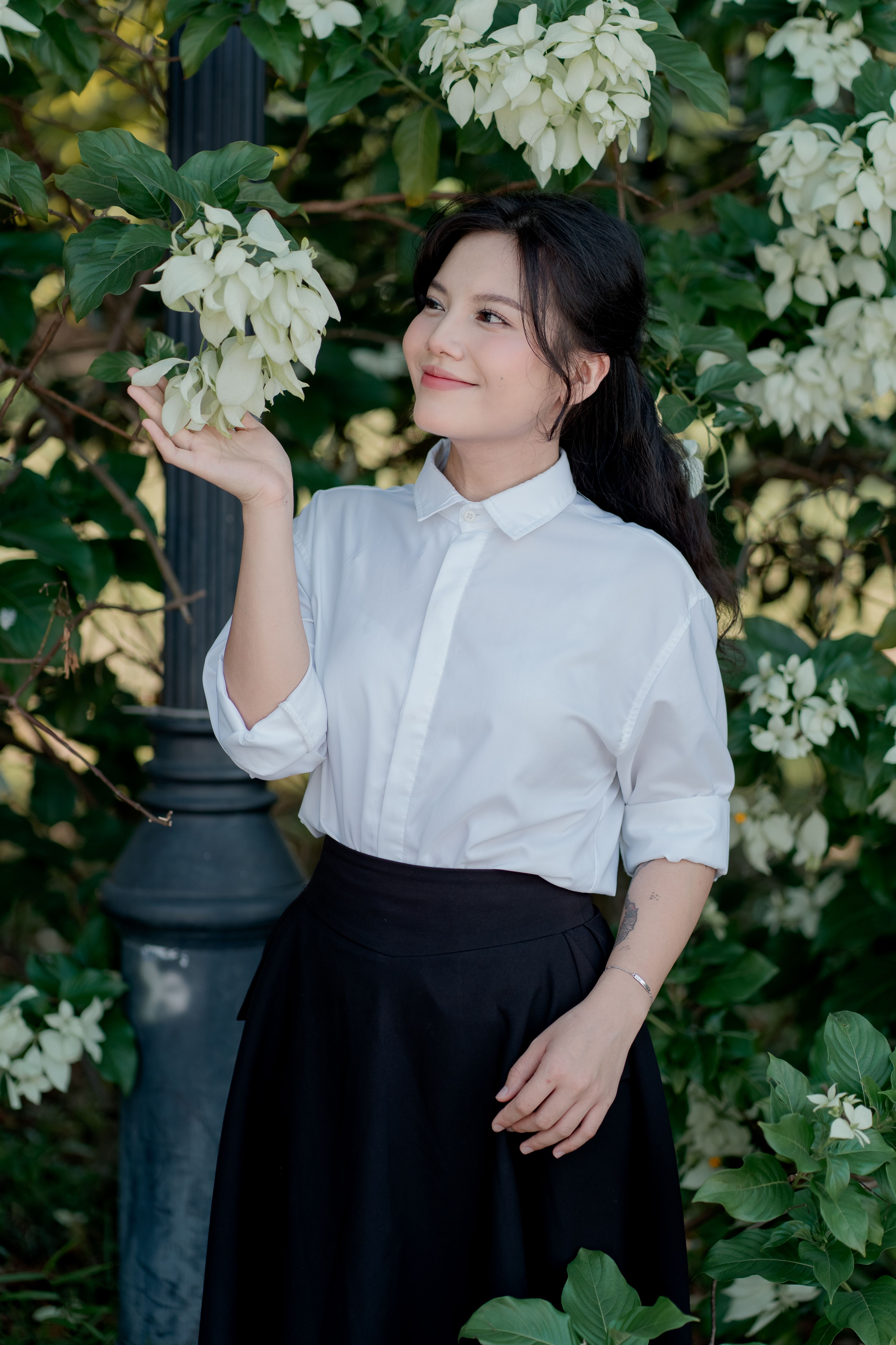 Woman in White Shirt Admiring Nature Blossoms · Free Stock Photo